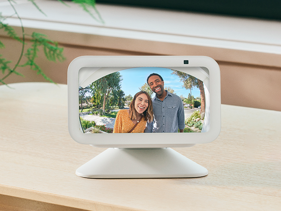 Two people appear smiling on the screen of an Amazon Echo Show device.