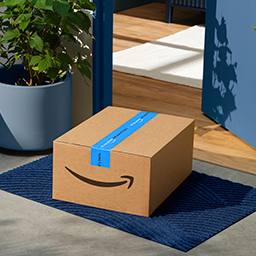 An Amazon box sits on a doorstep.