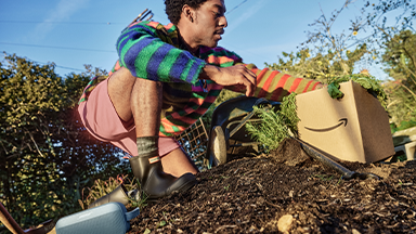 A person crouched down in a garden.